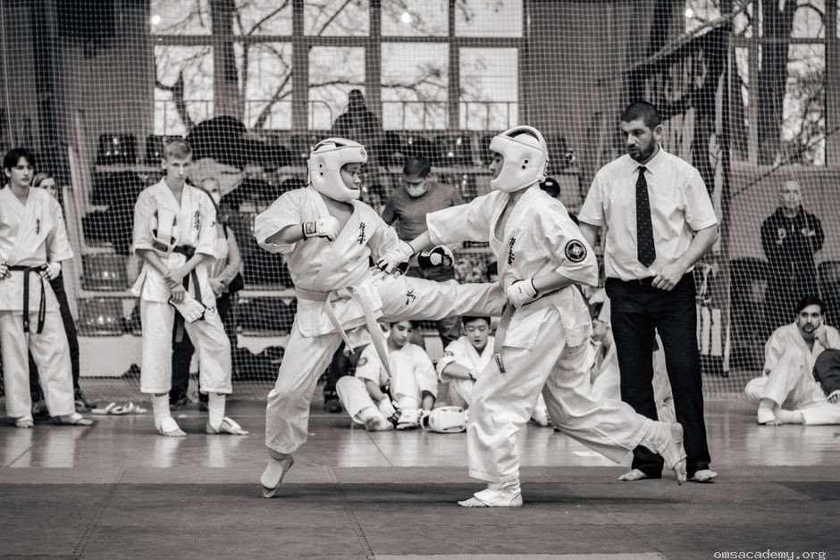 Two students in protective gear sparring during a Taekwondo competition at Om's Martial Arts & Fitness Studio in Jaipur.
