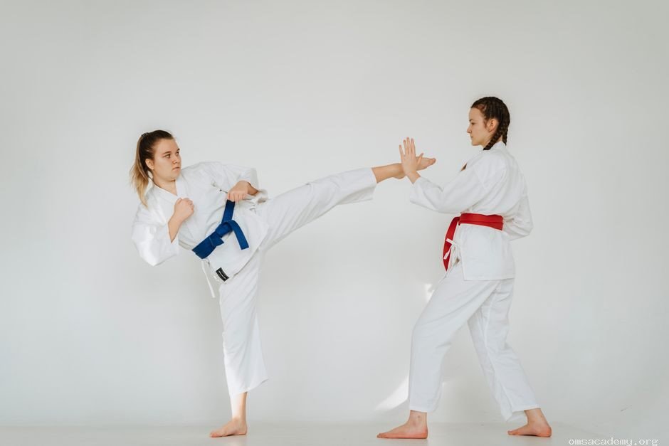 Two female students practicing Taekwondo sparring techniques at Om's Martial Arts & Fitness Studio in Jaipur.